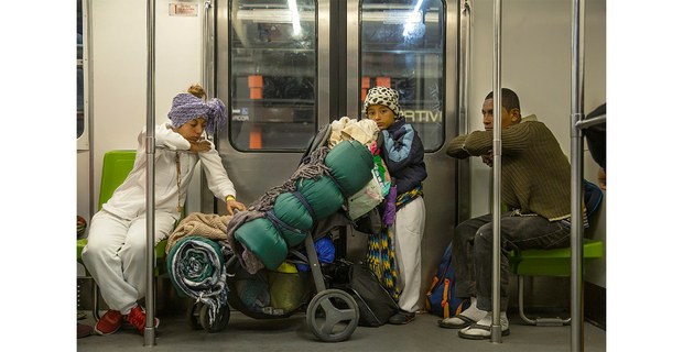 Familia migrante viaja en el Metro de la Ciudad de México, 2023. Foto: Víctor Mendiola