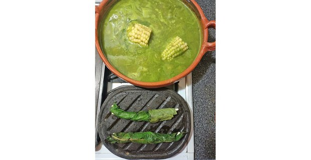 Chileatole con hoja santa y elote; en el comal de piedra, rollos de momo rellenos de quesillo con chapulines